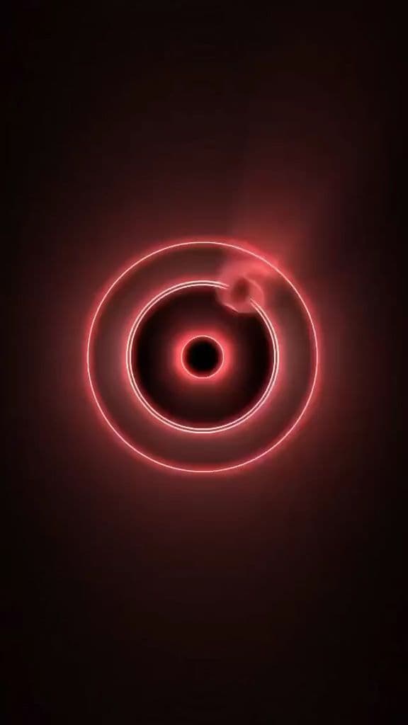 This may contain: a black background with red lights and a circular object in the center that appears to be an apple log