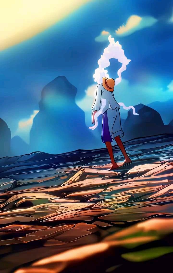 This may contain: a man standing on top of a rocky beach under a blue cloudy sky with mountains in the background